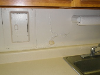 Wet plaster problem in kitchen near circuit breakers.