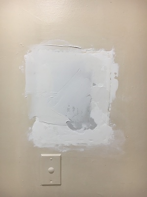 I plugged the hole with a custom shaped block of wallboard and some spackling. I left the button that used to unlock the front door for visitors.